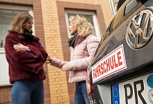 Zwei Frauen im Gespr&auml;ch hinter Fahrschulwagen - Christin Klose/dpa-tmn/dpa