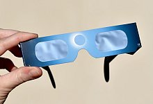 Die Sonnenfinsternis durch eine Spezialbrille beobachten - Foto: Ralf Hirschberger/dpa-Zentralbild/dpa-tmn