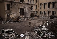 Ein ukrainischer Soldat geht an einem schwer beschädigten regionalen Verwaltungsgebäude in Charkiw vorbei. - Felipe Dana/AP/dpa