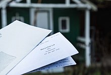 Grundsteuerbescheid von 2025 vor einem Haus - Christin Klose/dpa-tmn