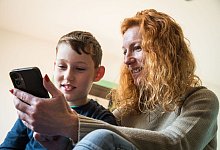 Mutter und Sohn schauen auf ein Smartphone - Christin Klose/dpa-tmn