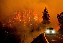 Ein Feuerwehrauto f&auml;hrt auf dem California Highway 96, w&auml;hrend das McKinney-Feuer im Klamath National Forest brennt. - Noah Berger/AP/dpa