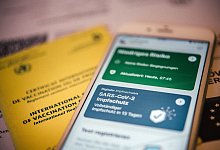 Impfnachweis in der App und auf Papier - Foto: Zacharie Scheurer/dpa-tmn
