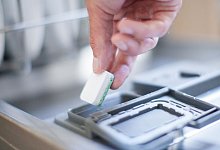 Mann legt einen Geschirrsp&uuml;ltab in eine Sp&uuml;lmaschine - Christin Klose/dpa-tmn