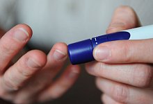 Eine Frau benutzt eine Stechhilfe f&uuml;r die Blutzuckermessung - Jens Kalaene/dpa-Zentralbild/dpa-tmn