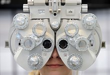 Frau sitzt hinter einem Phoropter, der die Sehstärke ermittelt - Andreas Gebert/dpa/dpa-tmn