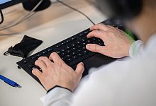 Mann arbeitet an einer Computer-Tastatur - Sebastian Gollnow/dpa/dpa-tmn
