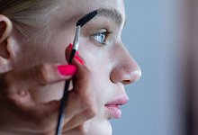 Visagistin stylt die Augenbrauen eines Models - Lisa Ducret/dpa/dpa-tmn