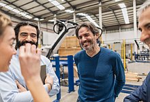 Älterer Mann unterhält sich lachend mit seinen Kollegen - Jose Carlos Ichiro/Westend61/dpa-tmn