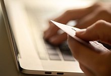 Person tippt Kreditkartendaten werden in PC ein - Franziska Gabbert/dpa-tmn