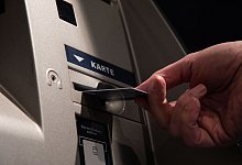 Ein Mann mit Karte an einen Bankautomaten - Christin Klose/dpa-tmn
