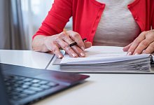 Eine Frau &uuml;berpr&uuml;ft Unterlagen - Christin Klose/dpa-tmn