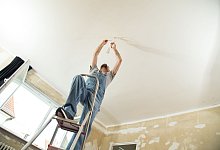 Mann montiert eine Deckenleuchte - Christin Klose/dpa-tmn