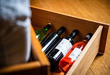 Weinflaschen liegen in einem Bettkasten - Zacharie Scheurer/dpa-tmn