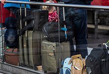 Reisende an einem Bahnsteig - Paul Zinken/dpa