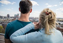 Ein Paar geniesst die Aussicht von einem Balkon - Christin Klose/dpa-tmn