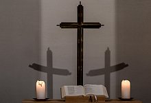 Brennende Kerzen und Kreuz - Jens Kalaene/dpa/Symbolbild