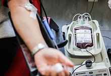 Eine Person spendet Blut im DRK-Blutspendezentrum - Oliver Berg/dpa