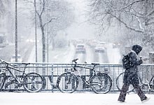 Schneebedeckte Fahrr&auml;der im dichten Schneetreiben - Rolf Vennenbernd/dpa/dpa-tmn