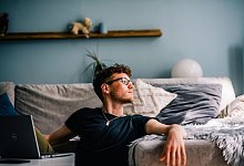 Ein junger Mann sitzt auf dem Boden vor seinem Computer - Zacharie Scheurer/dpa-tmn