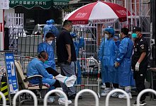 Medzinisches Personal steht am Eingang einer abgeriegelten Gemeinde in Peking: Auf der Suche nach dem Ursprung des Coronavirus Sars-CoV-2 kommt Wissenschaftlern zufolge wahrscheinlich ein Markt in Wuhan in Betracht. - Ng Han Guan/AP/dpa