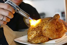 Ein H&auml;hnchen mit einem Bunsenbrenner br&auml;unen - Franz-Peter Tschauner/dpa/dpa-tmn