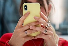 Eine junge Frau schaut auf ihr Handy - Bernd Diekjobst/dpa-tmn