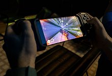 Mann streamt Spiel auf einem Smartphone - Florian Schuh/dpa-tmn