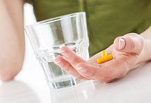 Eine Person mit Tablette und Wasserglas - Christin Klose/dpa-tmn