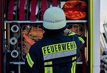 Feuerwehrmann am Einsatzfahrzeug - Rolf Vennenbernd/dpa