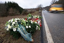 Blumen und Kerzen stehen an dem Tatort, an dem Ende Januar 2022 bei Kusel die beiden Polizeibeamten bei einer Verkehrskontrolle erschossen wurden. - Sebastian Gollnow/dpa