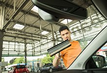 Ein Mann reinigt die Windschutzscheibe seines Autos - Christin Klose/dpa-tmn