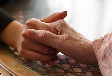 Frau und ihre Mutter halten sich an den H&auml;nden - Silvia Marks/dpa-tmn