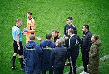 Spieler und Verantwortliche diskutieren mit Schiedsrichter Christian Dingert (l). - Philipp von Ditfurth/dpa