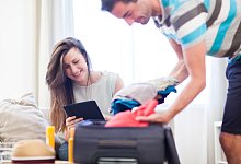 Sie bucht eine Reise, er packt - Foto: Christin Klose/dpa-tmn