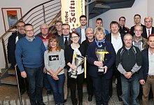 Um diese zwei Pokale geht es: LZ-Marketing-Leiterin Barbara Lucas (links, hält den Männerpott) und Elke Albert von Titelverteidiger FC Donop/Voßheide mit Sponsoren, Ausrichtern und Offiziellen der FuL-Kreise. Foto: Paul Cohen - Paul Cohen