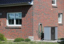 Eine Luft-Wasser-Wärmepumpe steht vor einem Haus - Jan Woitas/dpa/dpa-tmn