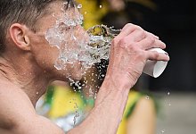 Ein Mann schüttet sich Wasser ins Gesicht - Sebastian Gollnow/dpa/dpa-tmn