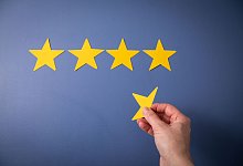 Eine Person legt gelde Sterne auf eine blaue Unterlage - Christin Klose/dpa-tmn