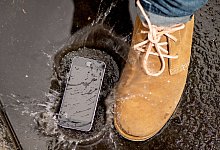 Smartphone liegt in Pfütze - Zacharie Scheurer/dpa-tmn/dpa