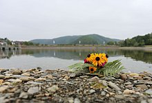 Blumen liegen am Ufer des Eiserbachsees f&uuml;r die verungl&uuml;ckten Kinder. - Ralf Roeger/dpa