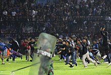 Fußballfans stürmen das Spielfeld im Kanjuruhan-Stadion nach dem Spiel zwischen Arema FC und Persebaya FC. - Yudha Prabowo/AP/dpa
