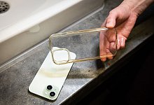 Frau h&auml;lt vergilbte Handyh&uuml;lle in der Hand - Christin Klose/dpa-tmn