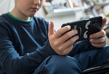 Junge schaut auf sein Smartphone - Christin Klose/dpa-tmn