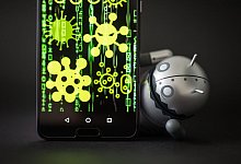 Eine Android-Figur erscheint hinter einem Smartphone - Arne Immanuel Baensch/dpa-tmn