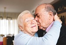 Ein &auml;lteres Ehepaar k&uuml;sst und umarmt sich liebevoll - Gemma Ferrando/Westend61/dpa-tmn