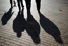 Schattenumrisse einer Gruppe auf Kopfsteinpflaster - Stefan Sauer/dpa-Zentralbild/dpa-tmn