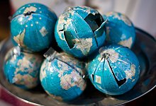 Besch&auml;digte Modelle von Erdkugeln liegen auf einem Tisch - Ole Spata/dpa/dpa-tmn