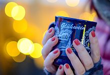 Frau hält Tasse mit Glühwein in den Händen - Jens Kalaene/dpa-Zentralbild/dpa-tmn