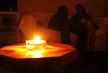 Ein Paar sitzt während eines Stromausfalls bei Kerzenschein in einer Wohnung. - picture alliance/dpa/Symbolbild
